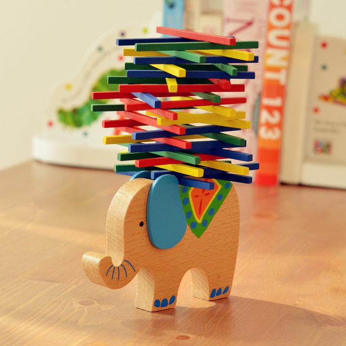 Colorful wooden balance toy shaped like an elephant on a wooden surface