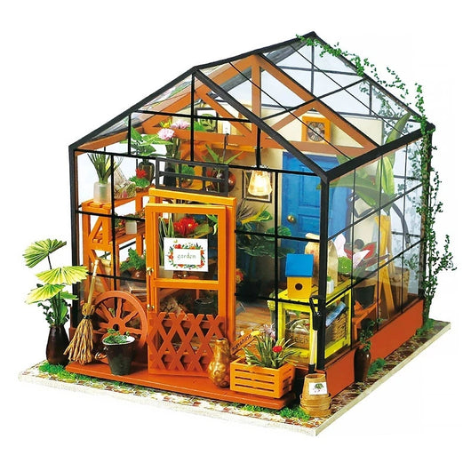 Model of a miniature greenhouse with various plants and decorations on a white background