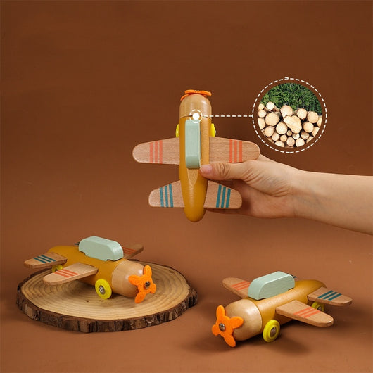 Wooden toy airplane held by a hand with a close-up of wood pieces on a brown background