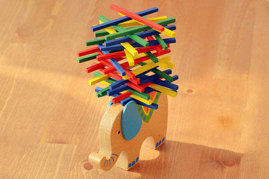 Colorful wooden toy elephant with interlocking sticks on a wooden surface