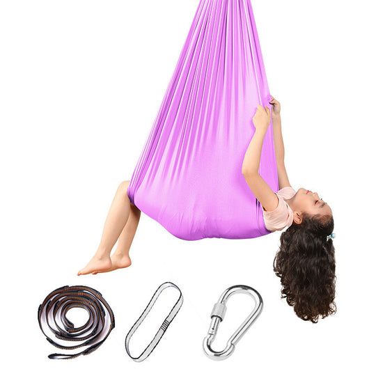 Person using a purple aerial yoga hammock with straps and carabiners on a white background