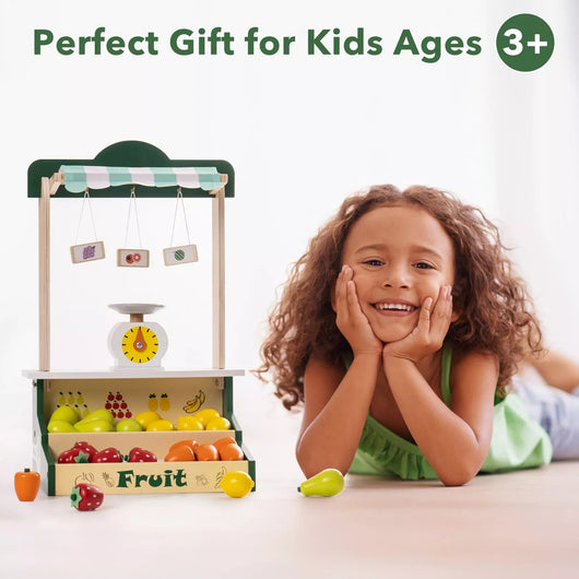 Child with a toy fruit stand and vegetables on a white background