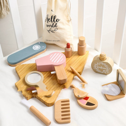 Set of wooden toys resembling a beauty salon on a white surface with a 'Hello World' bag in the background.