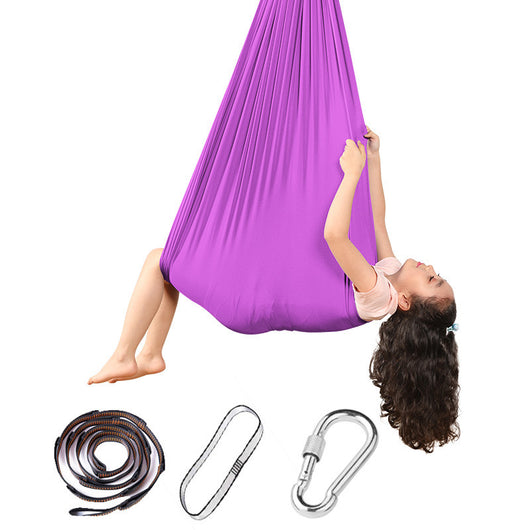 Person using a purple aerial yoga hammock with additional straps and carabiner on a white background