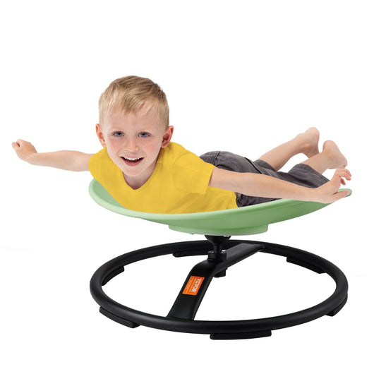 Child playing on a green and black wobble chair against a white background