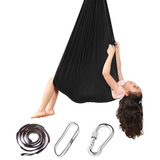 Person using a black aerial yoga hammock with accessories on a white background