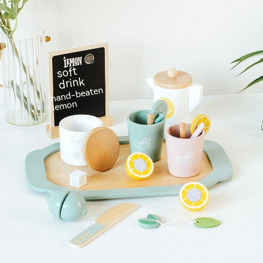 Tea set with cups, teapot, and a small chalkboard sign on a wooden tray.