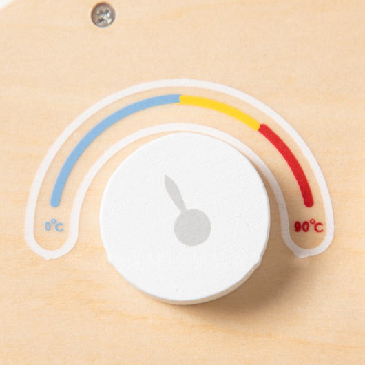 Temperature sensor with color-coded scale on a wooden background