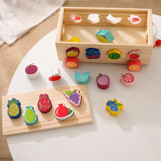 Wooden toy set with colorful fruit and vegetable shapes on a white surface