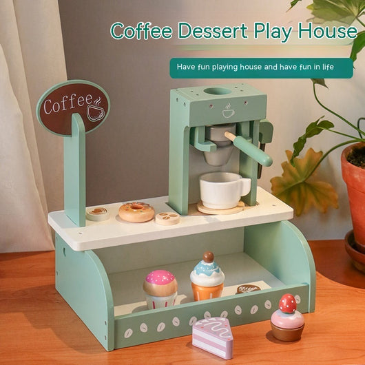 Toy coffee shop set with coffee machine, cups, and pastries on a wooden surface.