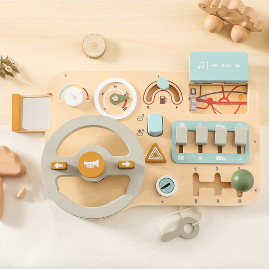 Wooden toy control panel with various buttons and levers on a light wooden surface.